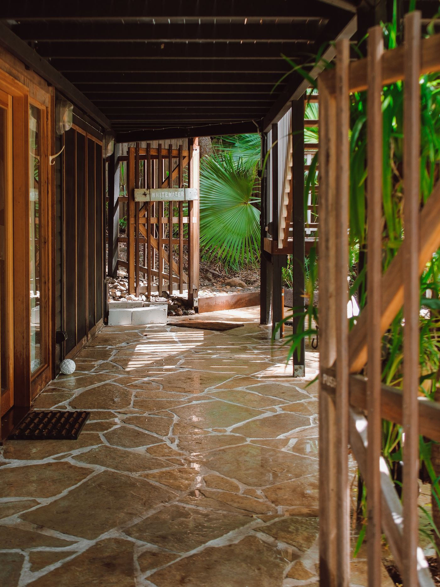 Sandstone crazy paving terraced beneath a rainforest home