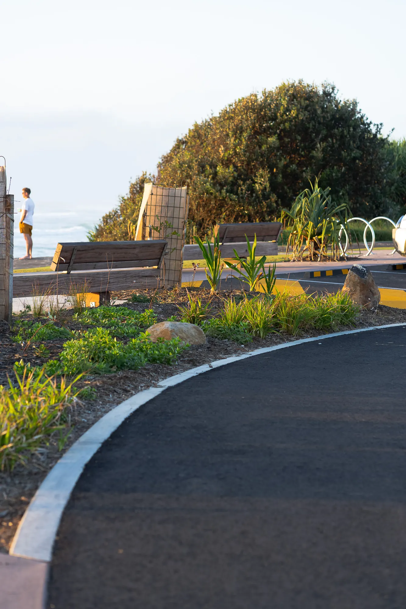 Kerb line, planting island and bench beside the shared path