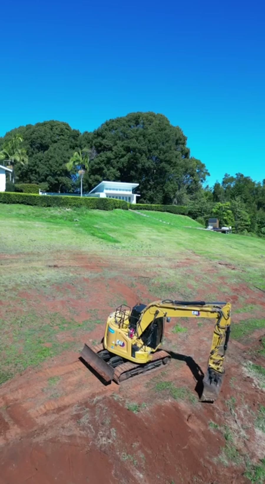 An excavator clearing a hillside site